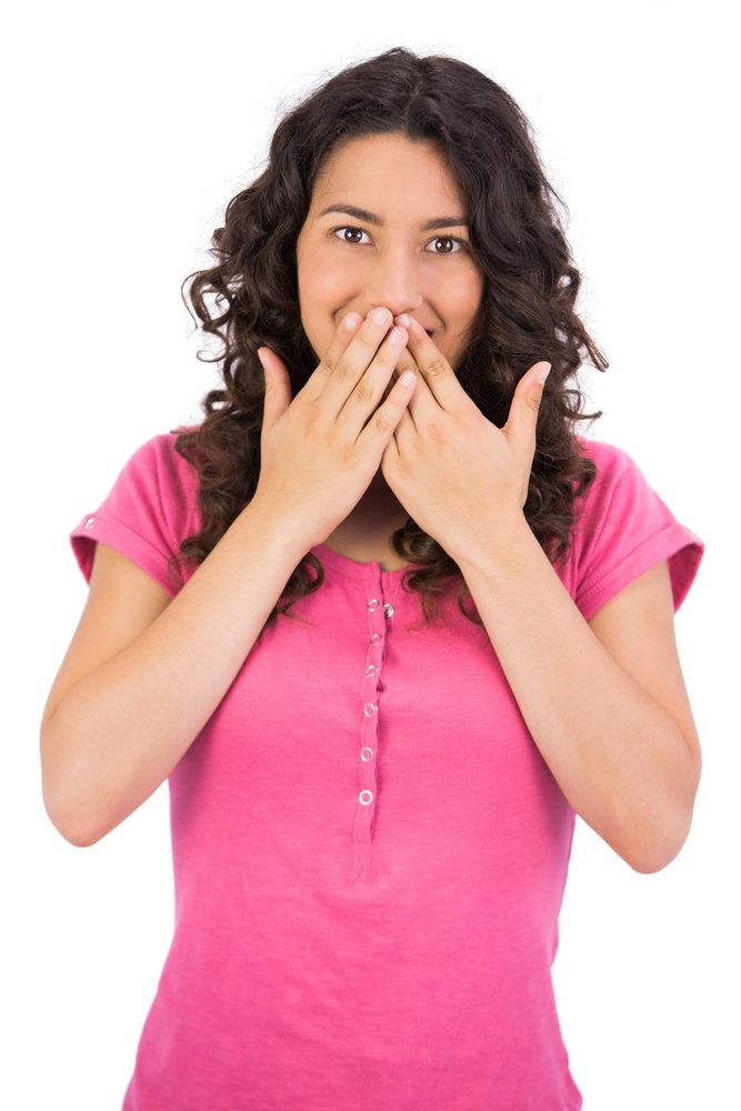 a young woman covering her mouth