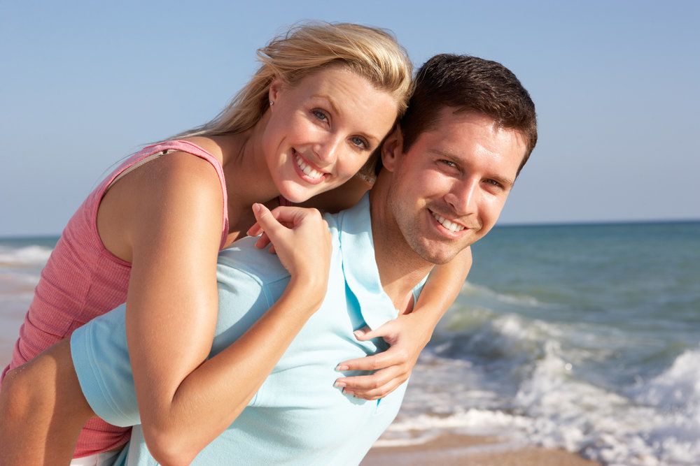 A happy couple, with beautiful smiles, on the beach