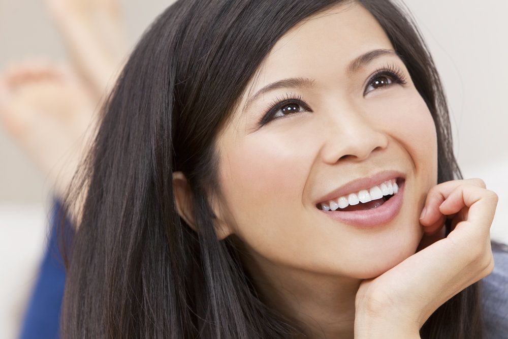 Smiling woman holding chin in hand